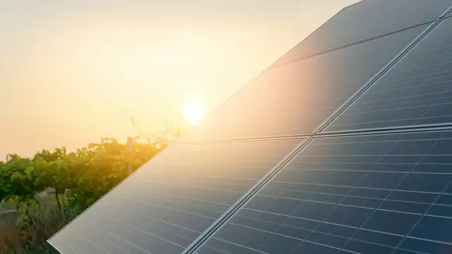 Ein modernes Einfamilienhaus mit Solaranlage, Regenwassertank und dichter Gebäudehülle – Symbol für nachhaltigen Hausbau
