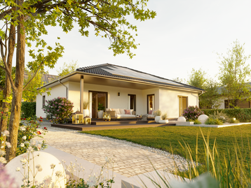 Gartenansicht des Winkelbungalow 108 mit überdachter Terrasse im geschützten Winkel, großen Fenstern und blühender Gartenanlage bei Sonnenuntergang.